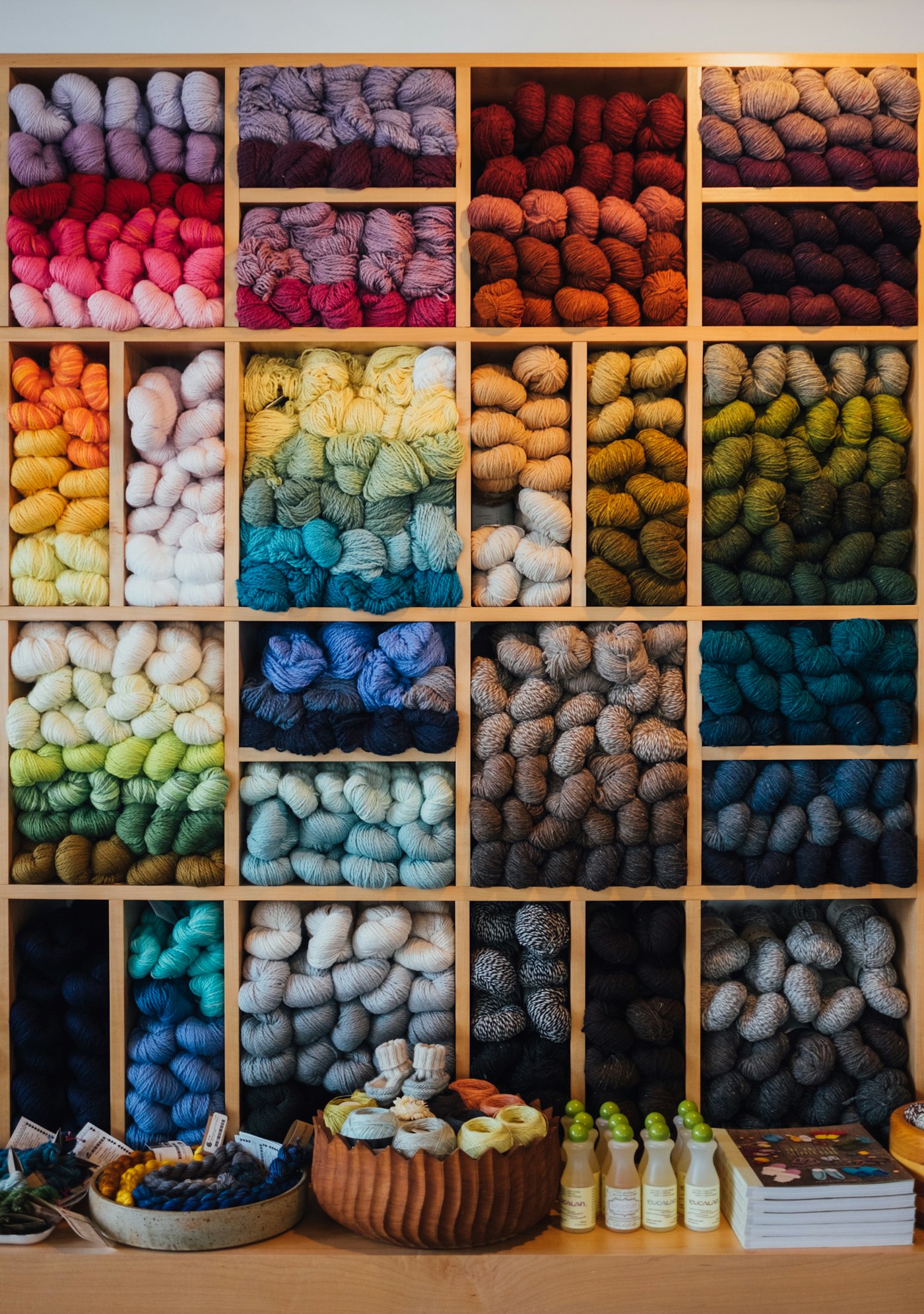 Yarn sorted by color in wooden cubbies