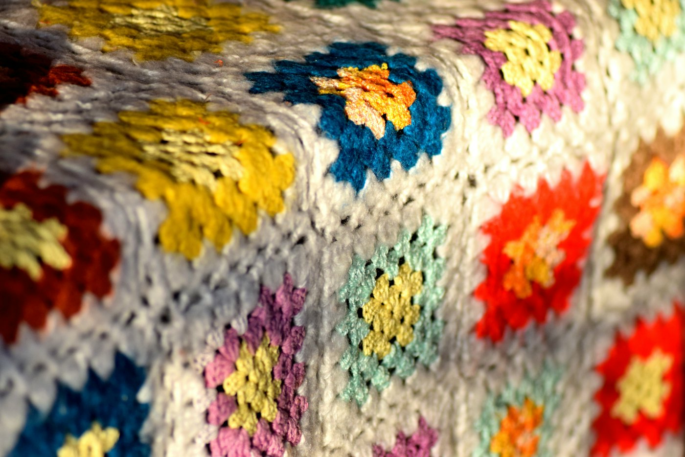 Close-up of a granny square blanket in yellow, blue, red and purple